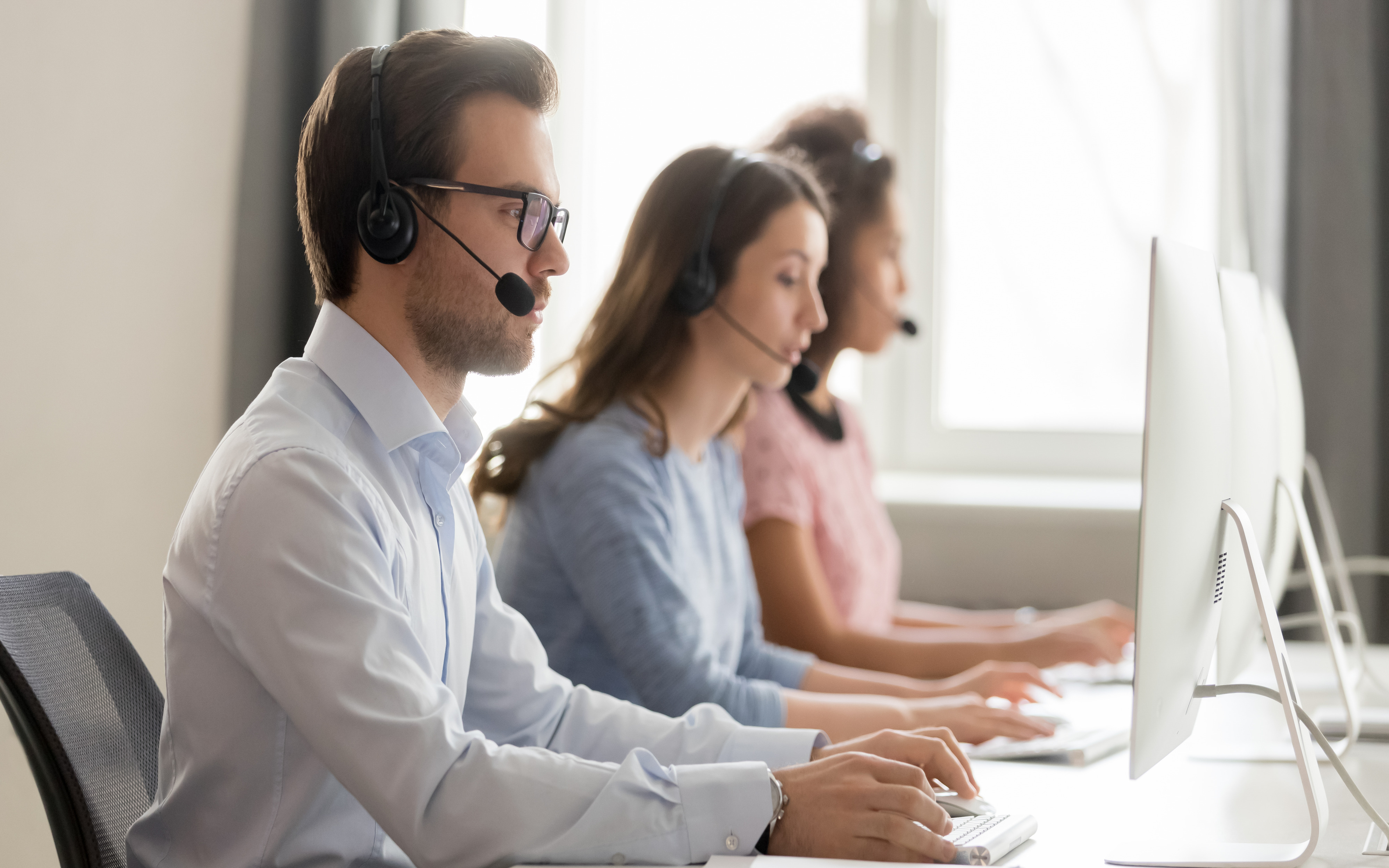 Professional People Sitting at Desk With Microphones